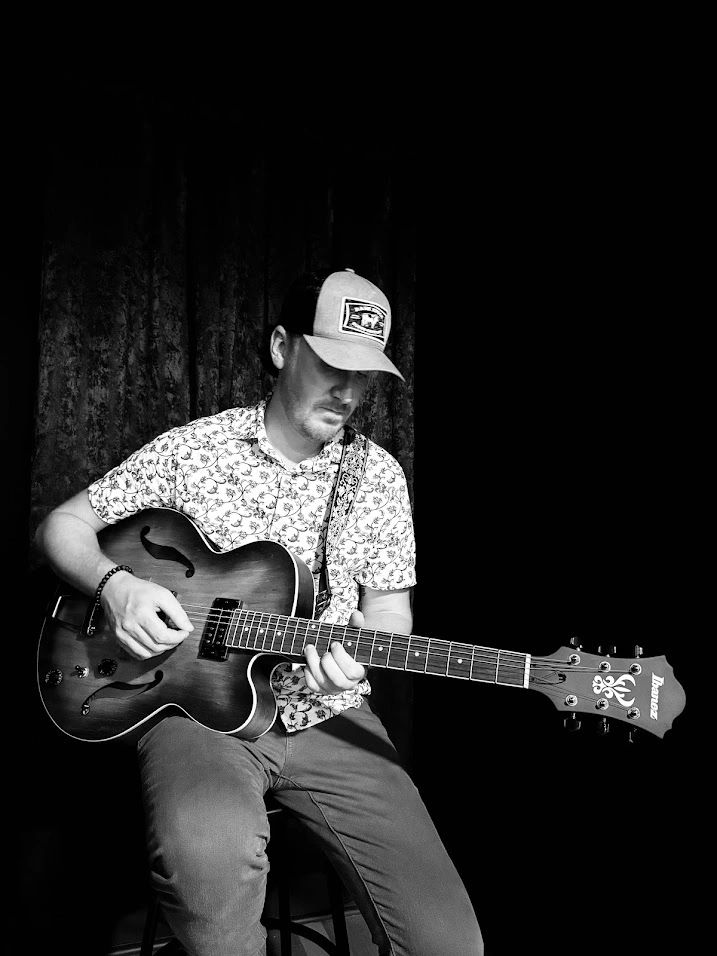 Weston Dean playing an Ibanez archtop guitar, black and white portrait